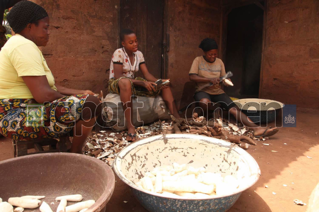 Mrs. Veronica Atuye (left) with her two daughters, Patricia (right) and Chikwadi peal cassaver tubes they havested from their farm in Agbor town, Delta state. Photo By Emmanuel Osodi