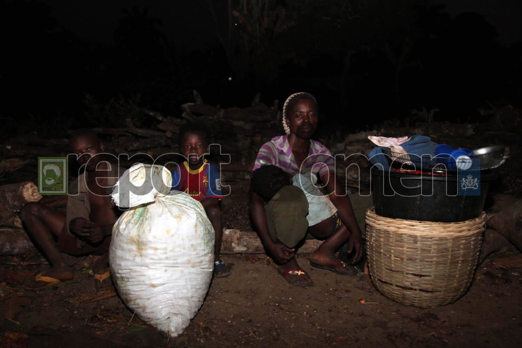 Funmi Toluwalase, breastfeeds her toddler, Femi while Ayo (left) and Tope  wait for their father at 7:33 pm,  Mr. Kayode Toluwalase, to carry their harvest home on his motorcycle (the mother and sons will follow on foot) after the day's job in the farm at Ajose camp near Ore  in Ondo State. Photo By Emmanuel Osodi